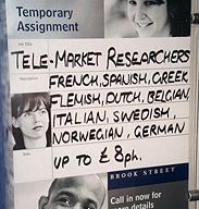 Sign in a shop window: 'Tele-market researchers wanted; Flemish, Dutch, Belgian. Up to 8 pounds per hour'.